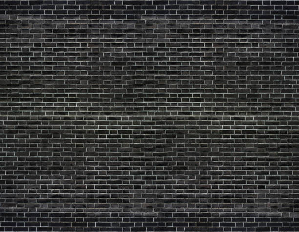 istock The dark black brick wall has a rough surface as a background image. 1159760869