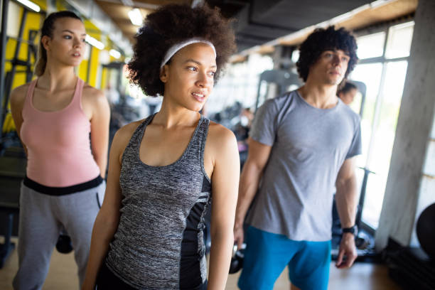 istock Group of young people doing exercises in gym 1159762067