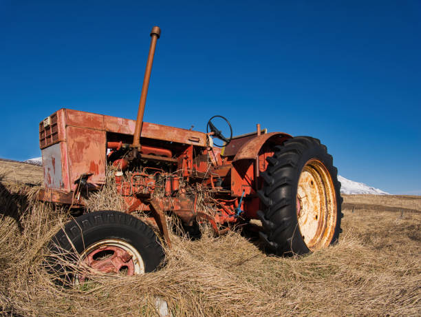 istock Old tractor standing on a meadow in the high grass 1159762078
