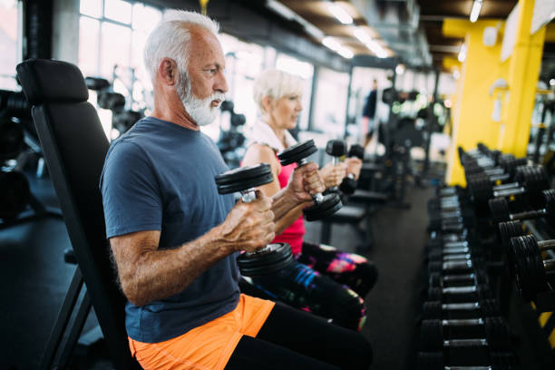 glücklich fit reifen mann im fitness-studio arbeiten, um gesund zu bleiben - gewichtetraining stock-fotos und bilder