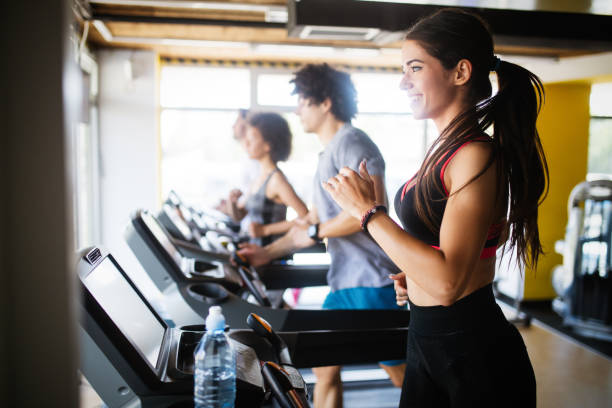 istock Group of sportive people in a gym training 1159762372