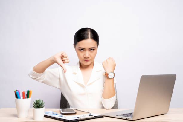 wściekła kobieta wskazuje na jej zegarek na rękę w biurze odizolowanym na tle - waiting women clock boredom zdjęcia i obrazy z banku zdjęć