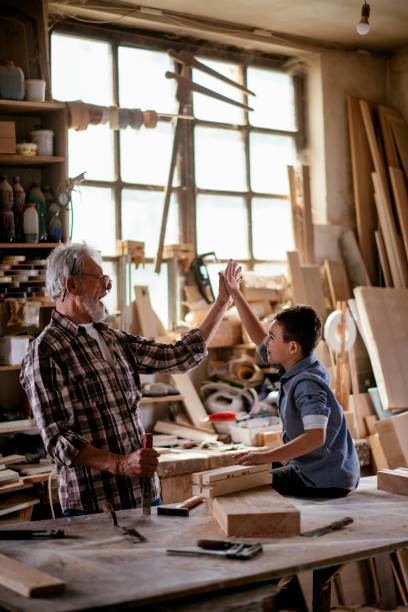 istock Senior carpenter and his grandson having fun in the workshop 1159763738