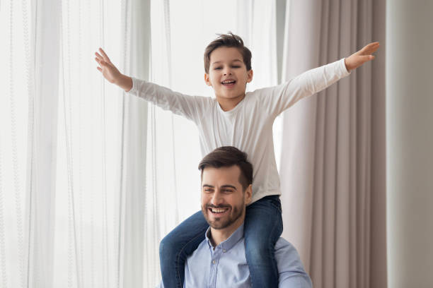 istock Happy father carry son on shoulders playing together 1159765386