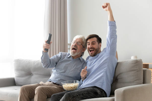 istock Excited elderly dad and son cheering watching TV game together 1159765851