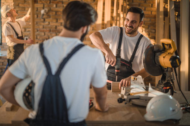 istock Happy manual worker talking to his colleague while working on home improvements. 1159766087