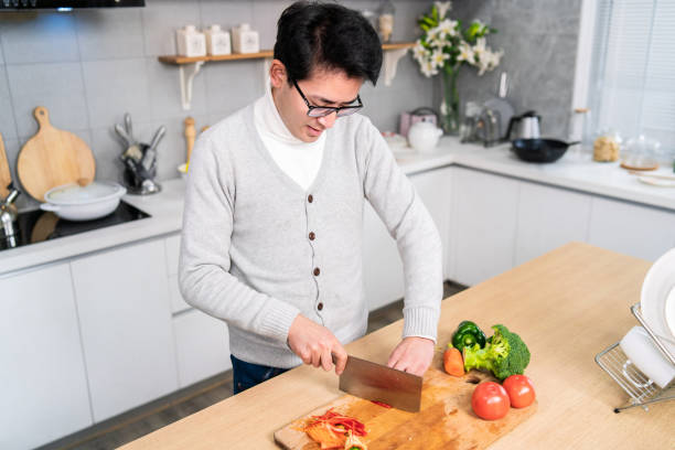istock Asian man cooking at home 1159766115