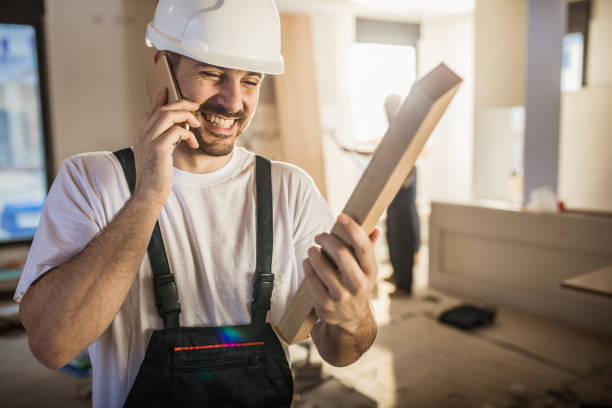 istock Happy manual worker talking on mobile phone at construction site. 1159768630