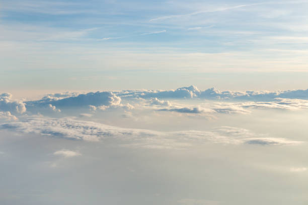 istock Cloudscape from above. View through a window of a modern jet airliner during sunset hours. 1159770203