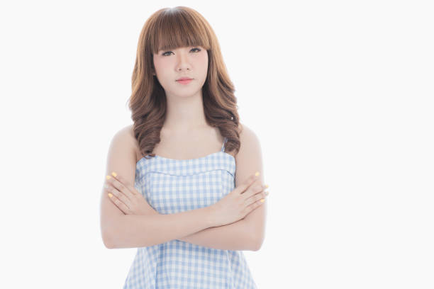 Front view close-up portrait of young beautiful Asian woman with curly long dark brown hair in light blue checked dress stand up straight  isolated white background