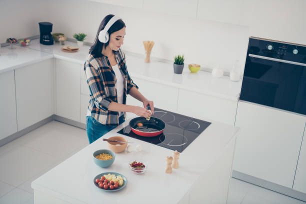 Top above high angle view photo charming concentrated beautiful lady, prepare feast supper evening routine hold hand utensils have headset sound melody checkered shirt plaid denim jeans stand apartment top por encima de la vista de ángulo alto foto encantadora concentrada hermosa señora preparar fiesta cena noche rutina sostener utensilios de mano tienen auriculares melodía sonido a cuadros camisa a cuadros jeans denim stand apartamento