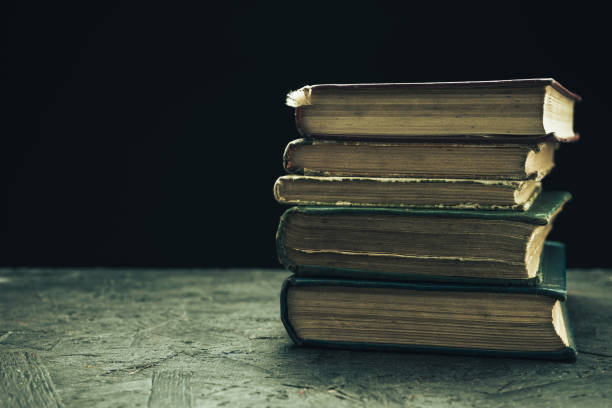 istock Old books on a wooden table black background. 1159774146