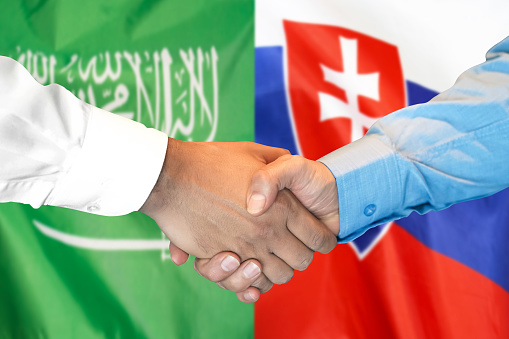 Business handshake on the background of two flags. Men handshake on the background of the Saudi Arabia and Slovakia flag. Support concept