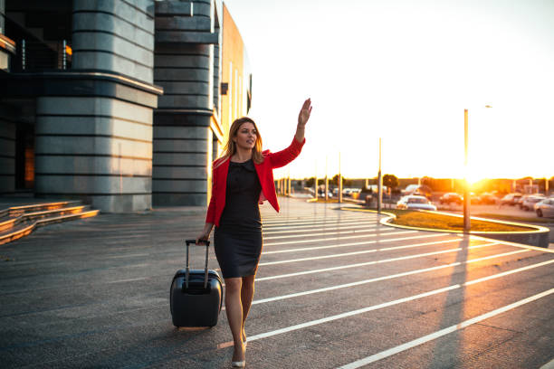 Attractive elegant woman waving to someone on the airport.