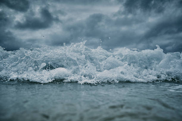 istock Breaking wave approaching the camera on the sea surface with a dark dramatic stormy sky. 1159783753