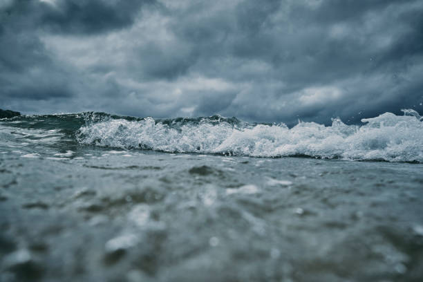 istock Breaking wave approaching the camera on the sea surface with a dark dramatic stormy sky. 1159783762