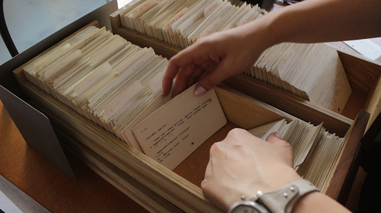 Portrait of a young Librarian labelling books with a barcode sticker on her work at the library