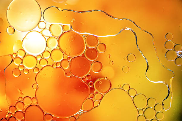 istock Bright yellow and orange colorful bubbles on water surface in abstract background 1159789627