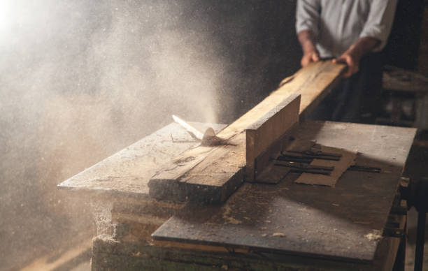 istock Carpenter cutting a wooden plank with a carpentry machine. 1159790290