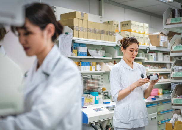 medicina fêmea da terra arrendada do farmacêutico na farmácia - pharmacy medicine pharmacist storage room - fotografias e filmes do acervo