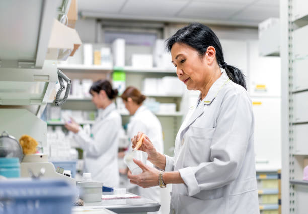 opinião lateral o farmacêutico maduro que trabalha na loja - pharmacy medicine pharmacist storage room - fotografias e filmes do acervo