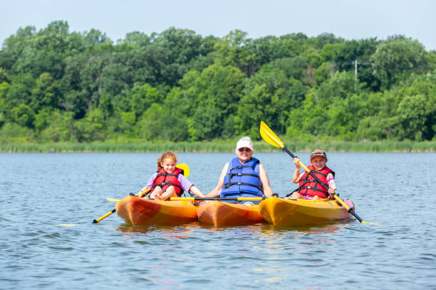 istock Grandma & Two Granddaughters In Kayaks on Lake 1159794636