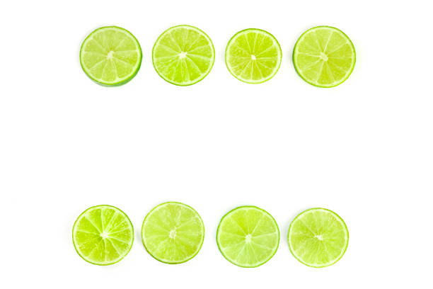 istock Vibrant lime slices, shot from the top on a white background, forming a frame with a place for text 1159795910