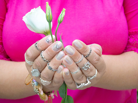 Close-up of woman's hands with many rings, jewelry, manicure