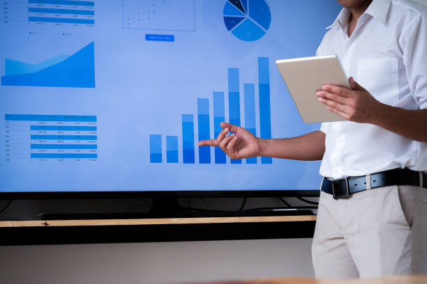 istock Speaker man talking to audience giving a lecture and holding tablet. Business presentation concept. 1159801203