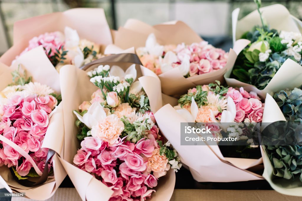 A lot of flower bouquets at the florist shop on the table made of hydrangea, roses, peonies, eustoma in pink and sea green colors Flower Stock Photo