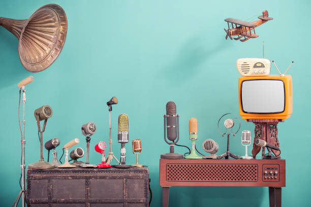 retro old microphones for press conference or interview, outdated tv, radio, flying wooden toy plane and gramophone horn front gradient aquamarine wall background. vintage old style filtered photo - radio gramophone imagens e fotografias de stock