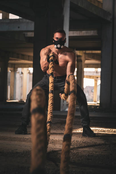 istock Muscular man training with battle ropes 1159804044