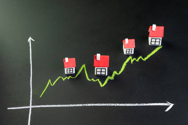 maison, propriété ou prix du marché immobilier monter ou concept en hausse, petite maison miniature avec graphique de ligne verte montant sur le tableau noir - stock market data finance chart home finances photos et images de collection