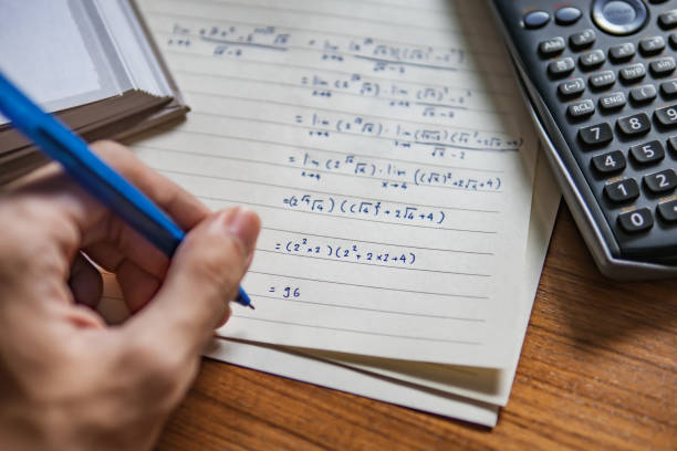 a left-handed person solving math problem a left-handed person solving math problem mathematics stock pictures, royalty-free photos & images