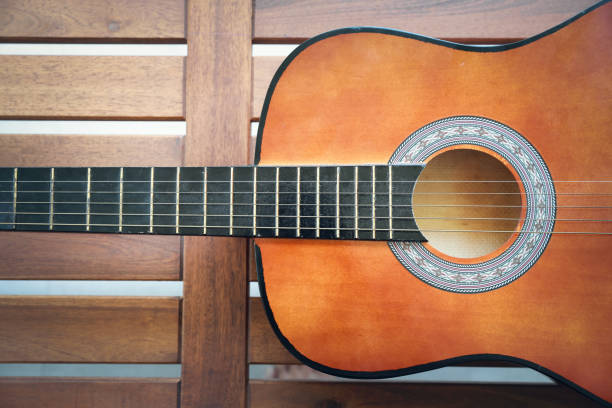 istock half acoustic guitar on wooden background 1159807075