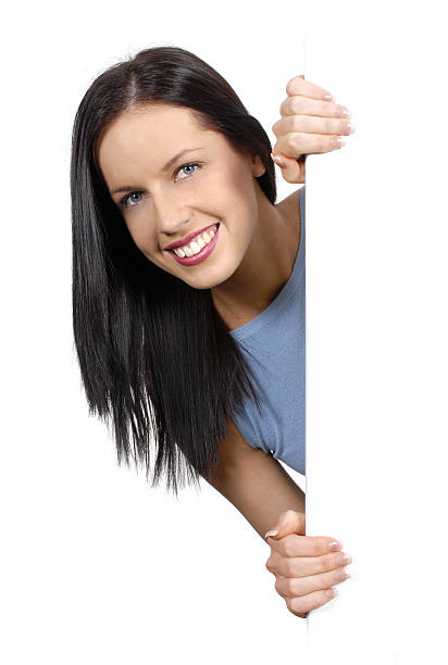 istock Friendly girl peeking round a white board 115980773