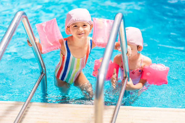 istock Cute little girls leaving the pool 1159808497