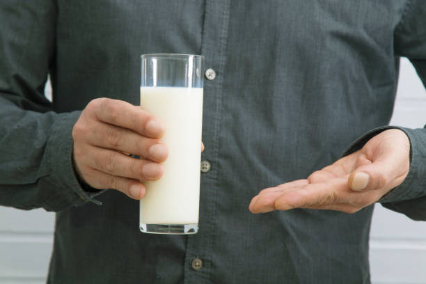 istock hand with glass of fresh milk 1159810183