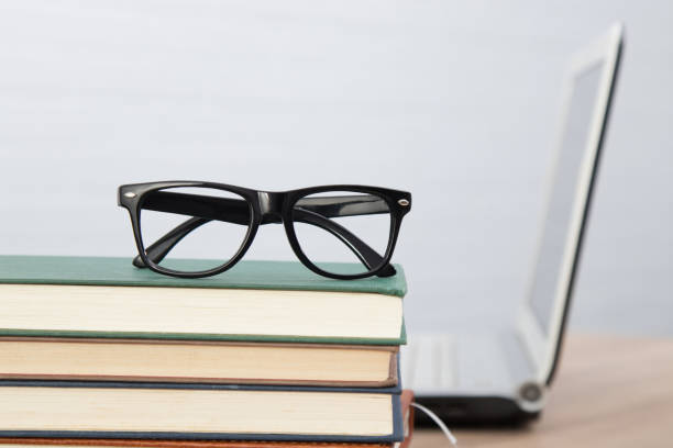 istock glasses on stacked books and laptop 1159810639