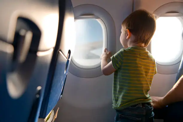 Little boy looking through airplane window