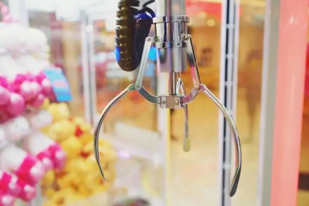Photo of Machine claw grabber game in a vending machine close up
