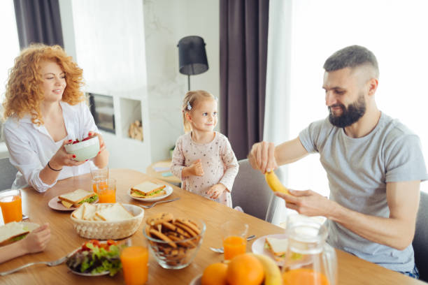 istock Joyful bearded man peeling a banana in his hand 1159816257