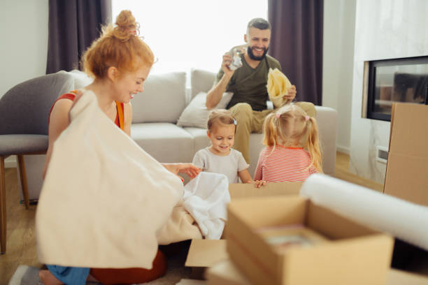 istock Delighted nice family unpacking their boxes together 1159816283