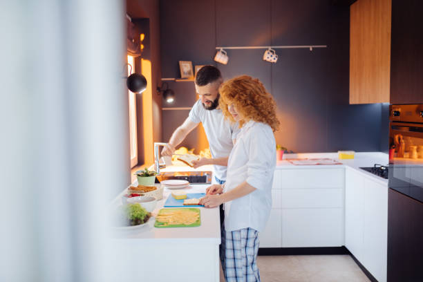 istock Nice bearded man helping his wife to make a sandwich 1159816489