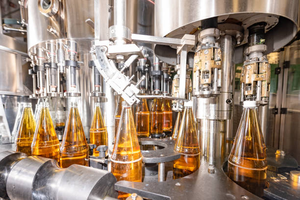 Filling  glass bottles with juice. Bottling of drinks. bottling plant
