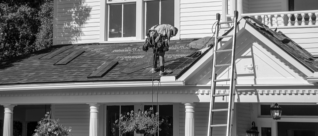 Belmont, North Carolina, USA - June 3, 2018: Roofing contractors replace roofs on residents’ homes in Belmont, North Carolina after a hail storm moved through the area on April 15, 2018. Golfball-sized hail was wide-spread and caused much property damage–especially to roofs. Roofing contractors are working seven days a week in temperatures over 90 degrees to meet demand from homeowners. Even at this rate, it could take several years to replace all of the roofs which received damage from the storm.