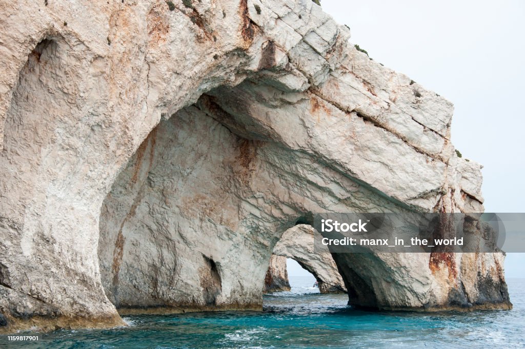 The Blue Caves-Zakynthos, Greece Zakynthos behoort met onder meer Lefkas en Kefalonia (ten noorden van Zakynthos) tot de Ionische Eilanden. 
Het eiland Zakynthos ligt in de Ionische zee, ten westen van het vasteland van Griekenland.  Rotsachtige zeekust met grotten en spelonken. Beach Stock Photo