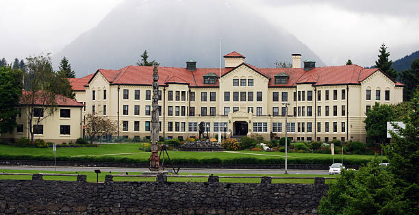 The Sitka Pioneer Home, part of the Alaska Pioneer Home, is a retirement/assisted living facility for Alaska residents. National Register of Historic Places. A statue titled The Prospector graces the front lawn. Totem Square in foreground. Sitka, Alaska, USA.