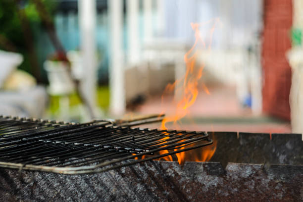 The grid of a grill gets warm on coals. Barbecue background with empty space