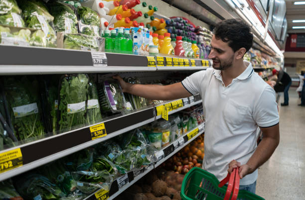 istock Latin american man grabbing spianch in a plastic container from the refrigerated section at the supermarket 1159821491